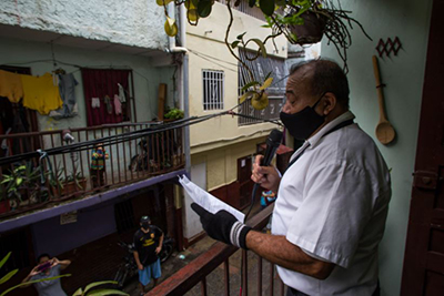 La Ventana TV (una versión de los aplausos europeos en las ventanas, pero dando noticias en el barrio La Cruz, Caracas). Fotos: Cristian Hernández